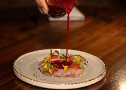 Garnish being placed on top of a fish dish at CISCo Restaurant + Bar