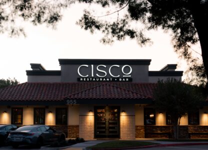 Photo of the front of CISCo Restaurant + Bar as the sun is setting behind it