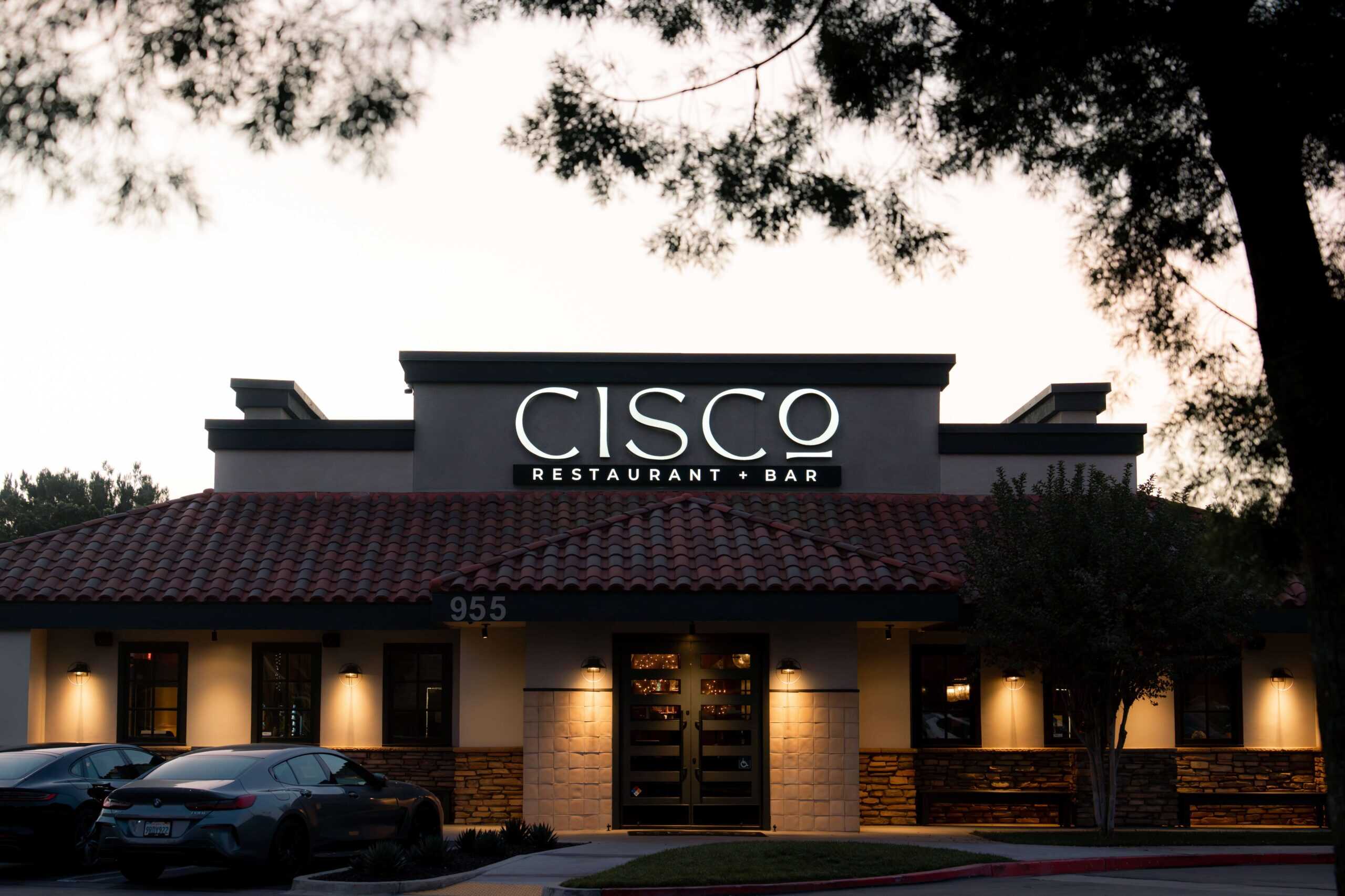 Photo of the front of CISCo Restaurant + Bar as the sun is setting behind it